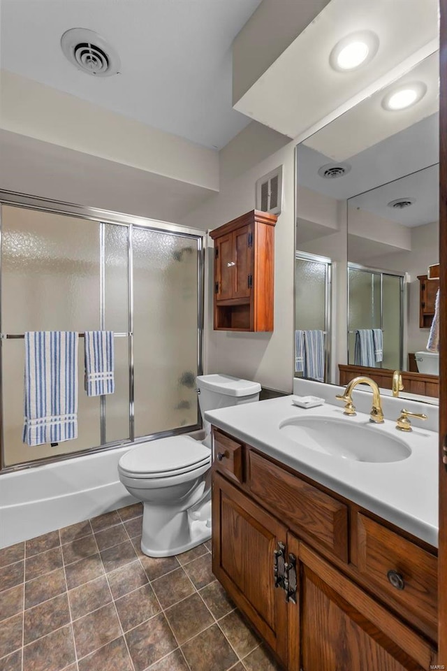 bathroom featuring toilet, vanity, and visible vents