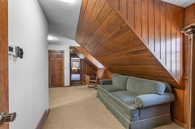 carpeted living room with wooden ceiling, wood walls, baseboards, and vaulted ceiling