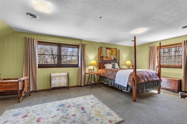carpeted bedroom with a textured ceiling and visible vents