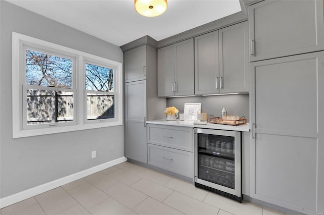 bar featuring baseboards and beverage cooler