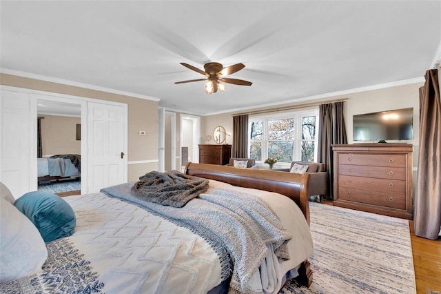 bedroom featuring ceiling fan, light wood-style flooring, and crown molding