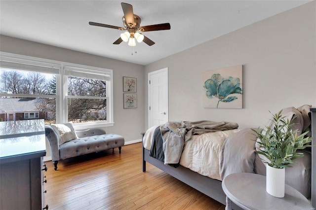 bedroom featuring a ceiling fan, light wood-type flooring, and baseboards