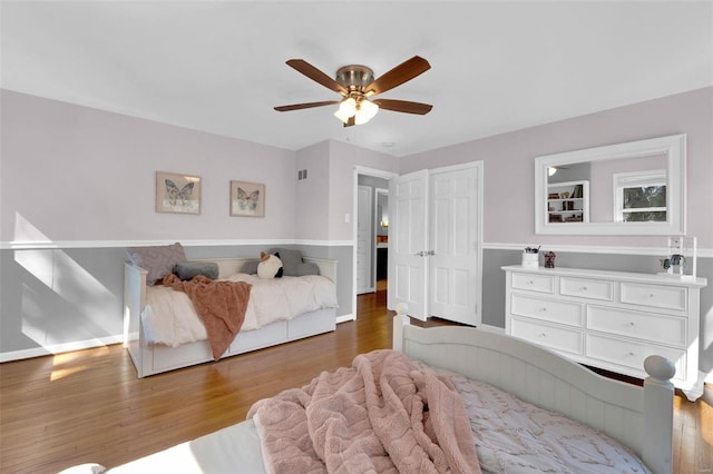 bedroom featuring a closet, ceiling fan, baseboards, and wood finished floors