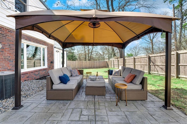 view of patio / terrace featuring outdoor lounge area, a gazebo, central air condition unit, and a fenced backyard