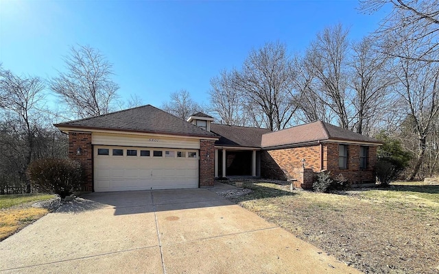 ranch-style home with brick siding, driveway, a garage, and roof with shingles