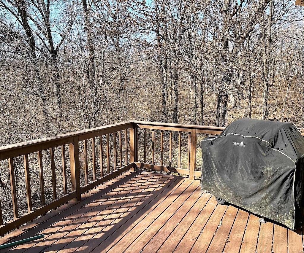 wooden deck featuring grilling area and a forest view