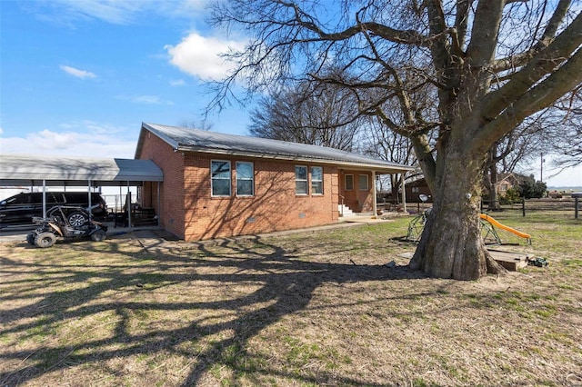 view of property exterior featuring crawl space, a lawn, brick siding, and a carport