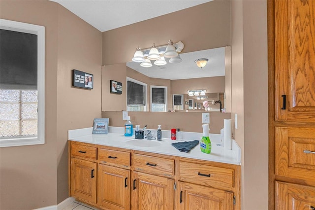 bathroom featuring baseboards, an inviting chandelier, and vanity