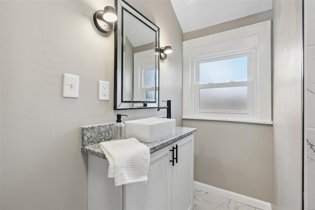 bathroom featuring baseboards, marble finish floor, and vanity