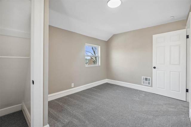 unfurnished bedroom featuring vaulted ceiling, baseboards, visible vents, and carpet floors