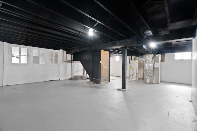 basement featuring gas water heater, stairway, and heating unit