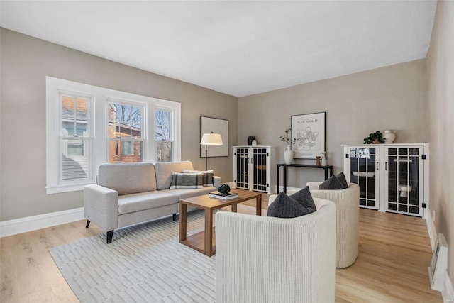 living room with baseboards and light wood-style flooring