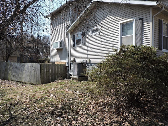 view of home's exterior featuring central AC unit and fence