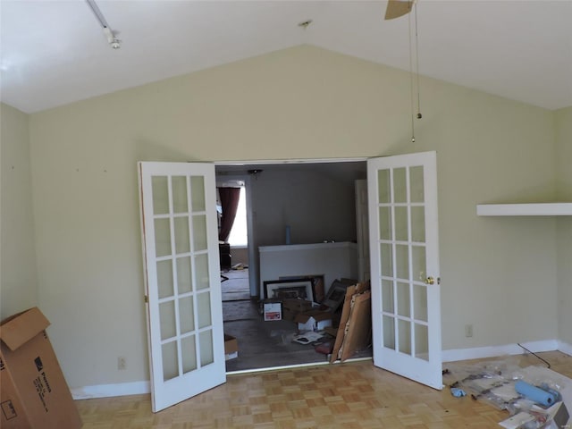 interior space featuring a ceiling fan, lofted ceiling, french doors, and baseboards