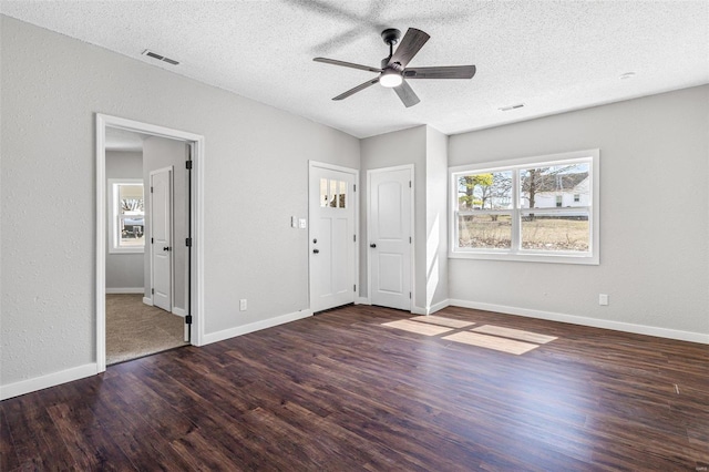 unfurnished bedroom with a textured ceiling, wood finished floors, visible vents, and baseboards