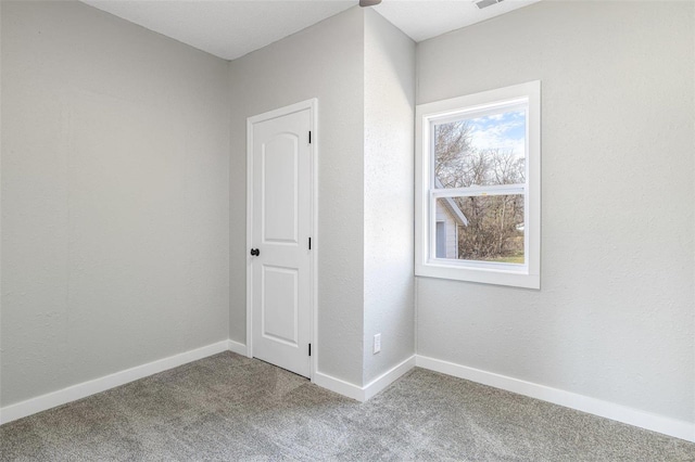 empty room featuring visible vents, baseboards, and carpet floors