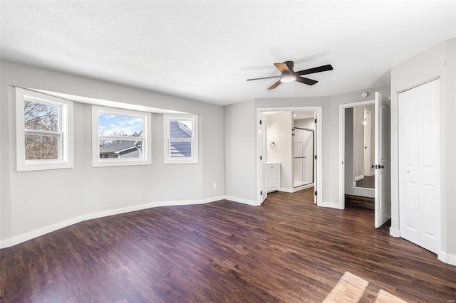 empty room with a textured ceiling, baseboards, a ceiling fan, and wood finished floors