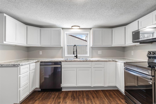 kitchen featuring dark wood-style floors, white cabinets, appliances with stainless steel finishes, and a sink