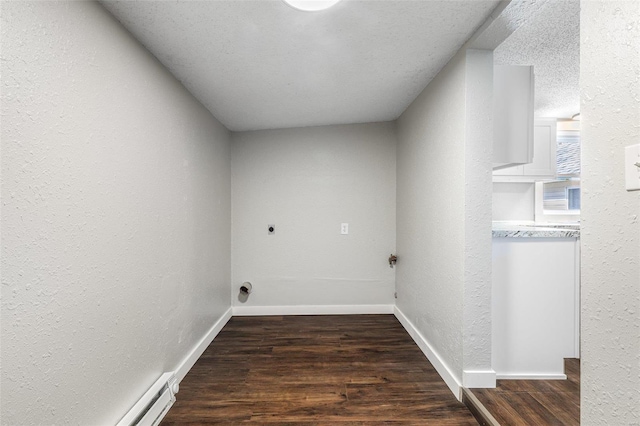 clothes washing area featuring hookup for an electric dryer, baseboards, a textured wall, and wood finished floors