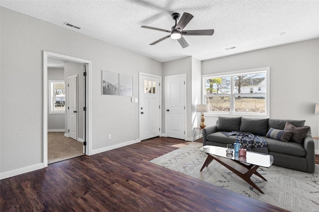 living area with visible vents, ceiling fan, and wood finished floors