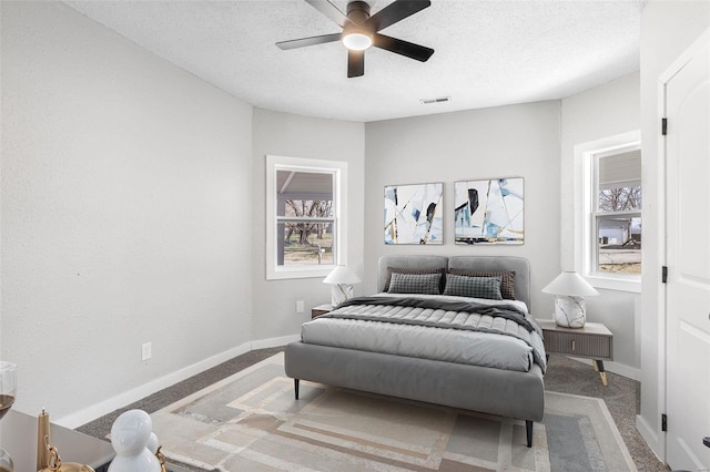 carpeted bedroom with baseboards, visible vents, and a textured ceiling