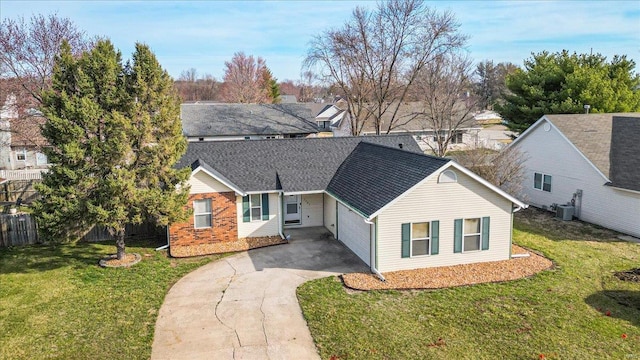 view of front facade with a front yard, fence, roof with shingles, central AC, and concrete driveway