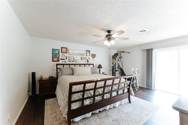 bedroom featuring wood finished floors, baseboards, visible vents, ceiling fan, and a textured ceiling