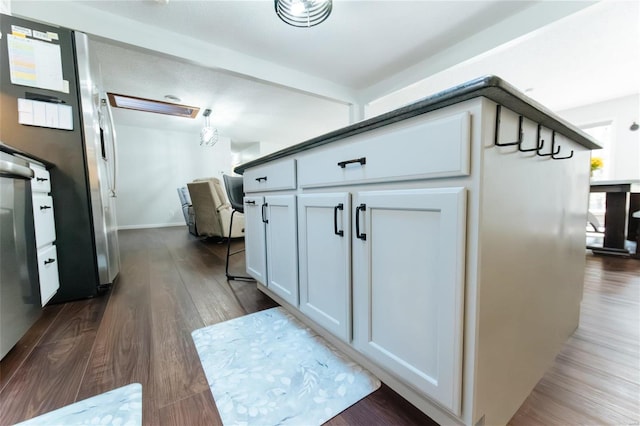 kitchen with dark wood finished floors, white cabinets, and baseboards