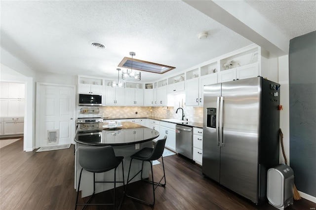 kitchen featuring a sink, visible vents, appliances with stainless steel finishes, and dark wood finished floors