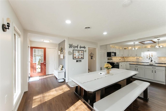 dining space with dark wood-style floors, visible vents, and recessed lighting