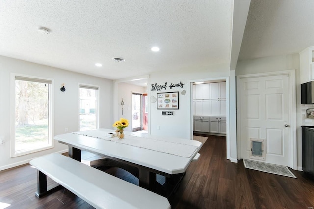 dining area featuring visible vents, baseboards, a textured ceiling, and dark wood-style floors