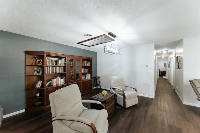 living area with visible vents, dark wood-type flooring, and baseboards