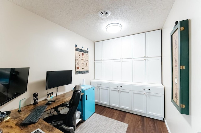 home office featuring visible vents, a textured ceiling, and dark wood-style flooring