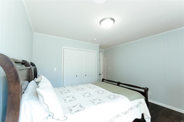 bedroom featuring a closet, dark wood-style flooring, and crown molding