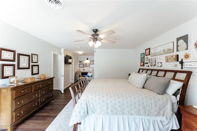 bedroom with a ceiling fan, dark wood-style floors, visible vents, and baseboards