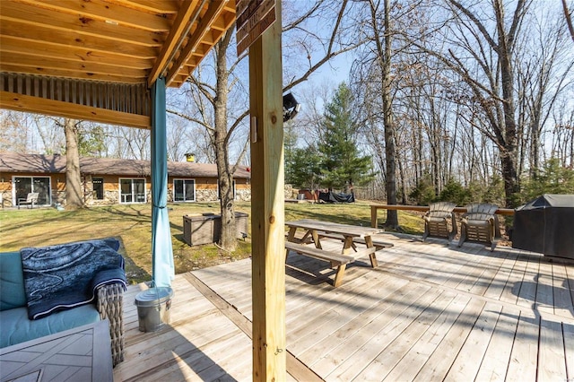 wooden terrace with a lawn and a grill