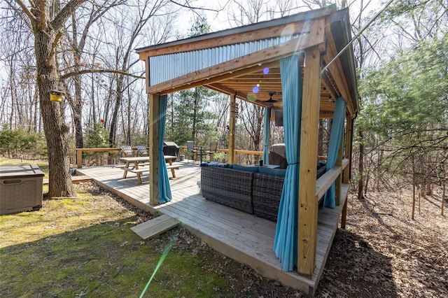 wooden deck with outdoor lounge area and a ceiling fan