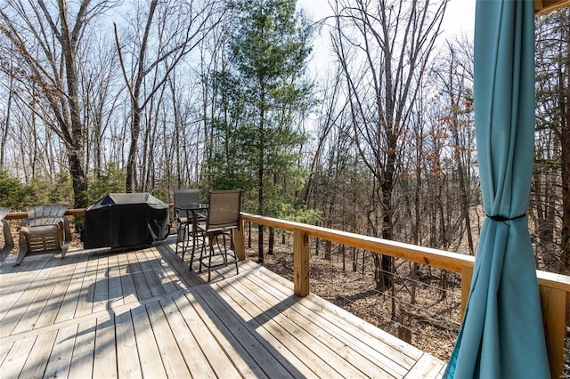 wooden terrace featuring outdoor dining area and a grill