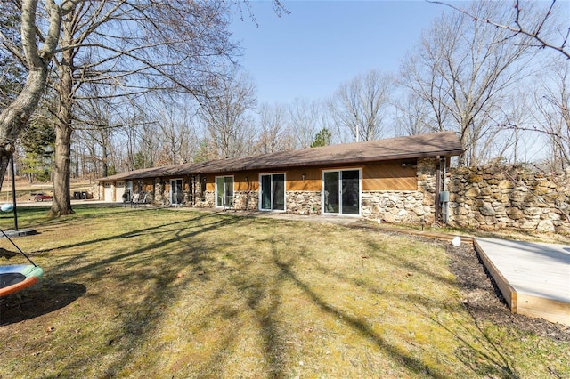 view of front facade featuring stone siding and a front yard