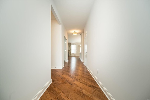 hall with baseboards and wood finished floors