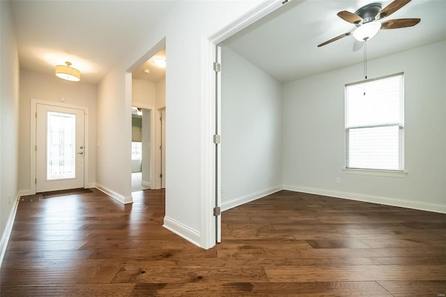 foyer entrance featuring a ceiling fan, baseboards, and dark wood-style flooring