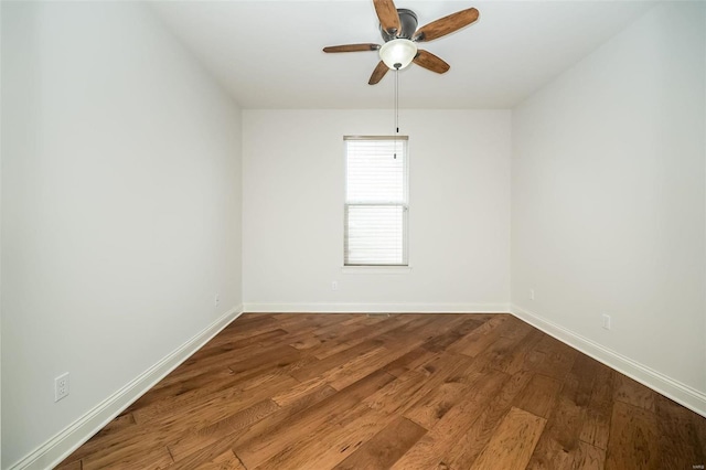 empty room with a ceiling fan, wood finished floors, and baseboards