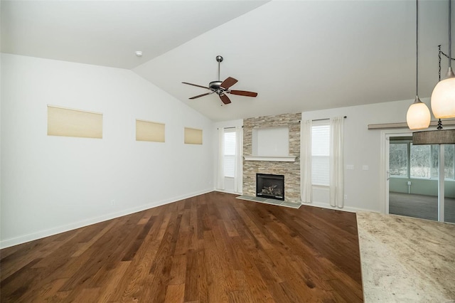 unfurnished living room with baseboards, dark wood finished floors, lofted ceiling, a fireplace, and a ceiling fan