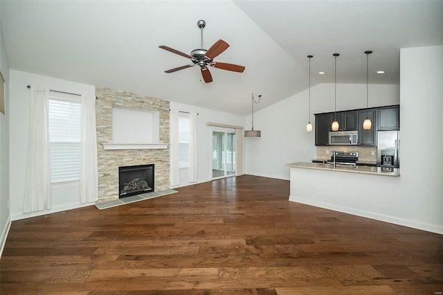 unfurnished living room with a stone fireplace, dark wood-type flooring, high vaulted ceiling, and ceiling fan