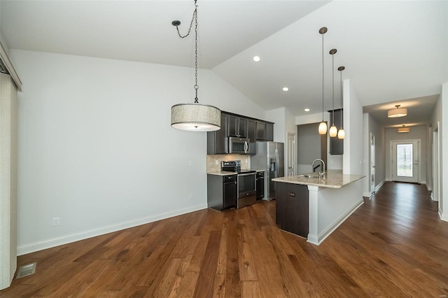 kitchen with dark wood finished floors, a sink, decorative backsplash, light countertops, and stainless steel appliances