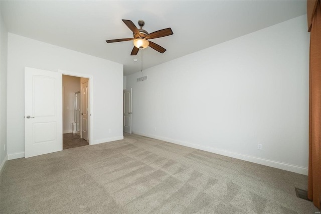 unfurnished bedroom with a ceiling fan, carpet, baseboards, visible vents, and ensuite bath