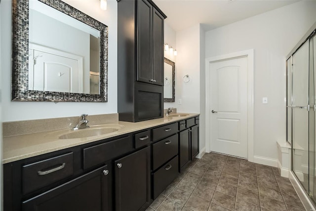 bathroom featuring double vanity, tile patterned floors, a shower stall, and a sink