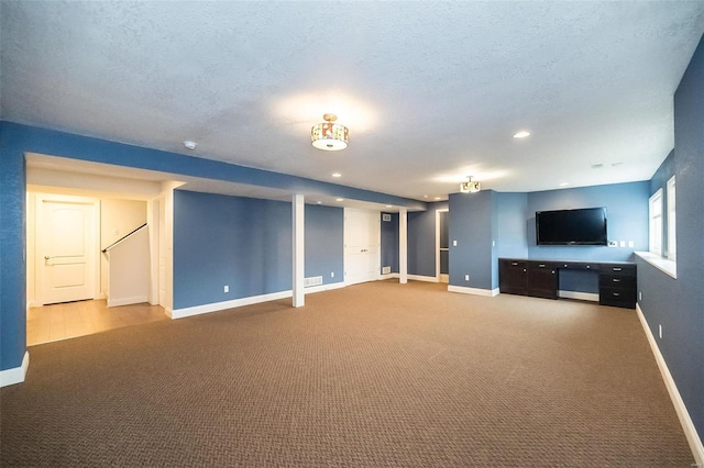 unfurnished living room with visible vents, baseboards, carpet flooring, recessed lighting, and a textured ceiling