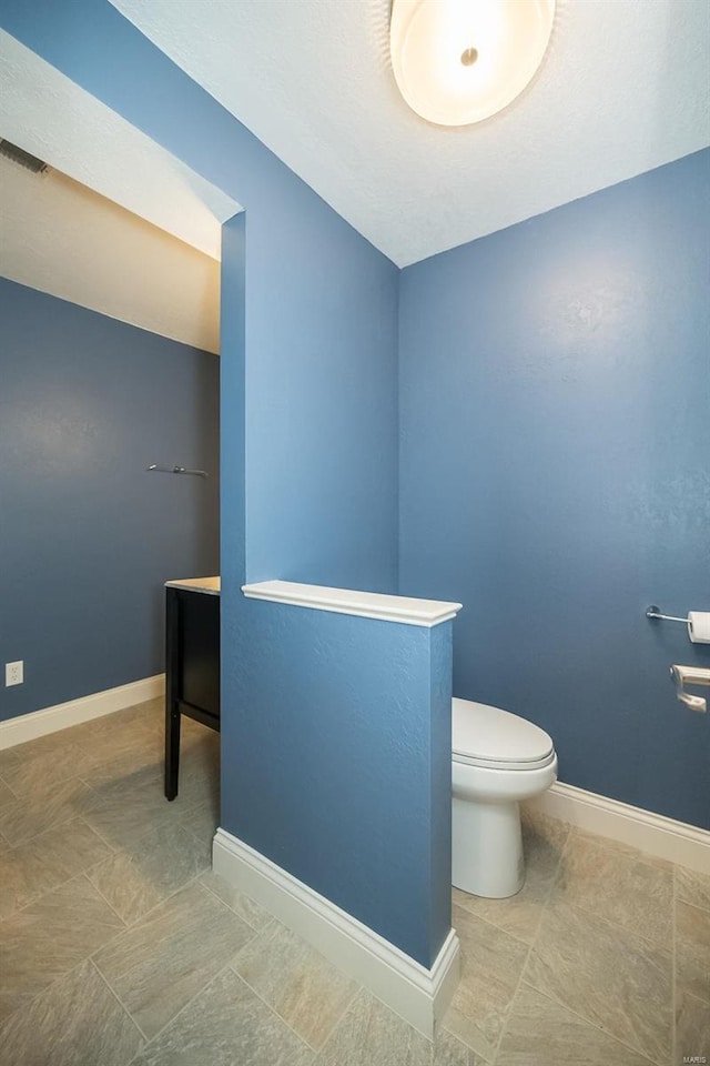 bathroom featuring tile patterned flooring, visible vents, toilet, and baseboards