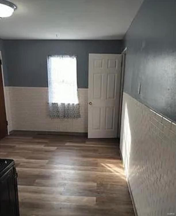 spare room featuring a wainscoted wall and wood finished floors